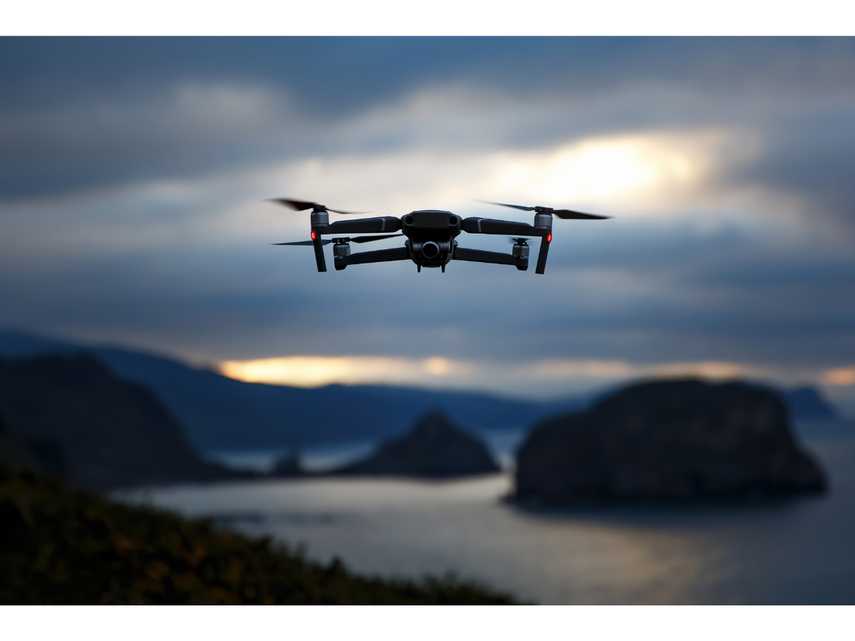 A drone flies over a riverbend surrounded by mountains.